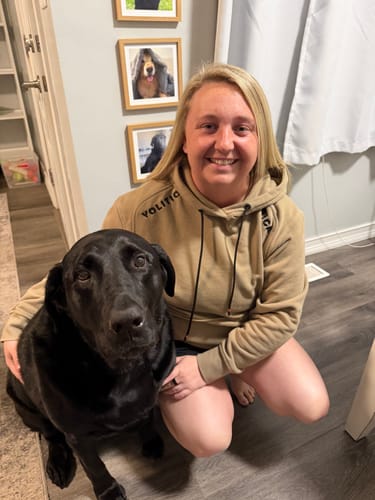 Customer photo: Madison F. and her dog, wearing the Operation Volition Hoodie